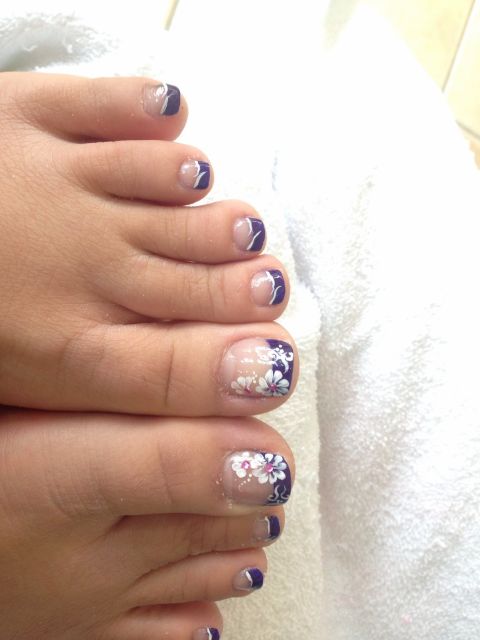 Purple French pedicure with white flower art and pink gems