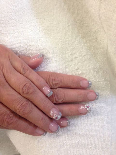 Silver glitter French tips with a white flower accent nail