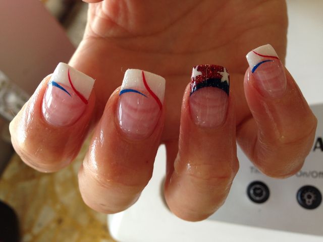 White French tips with red and blue swirls and a glitter flag accent