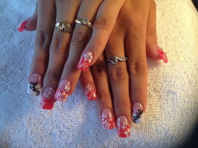 Coral glitter tips with white flowers and black swirl accents