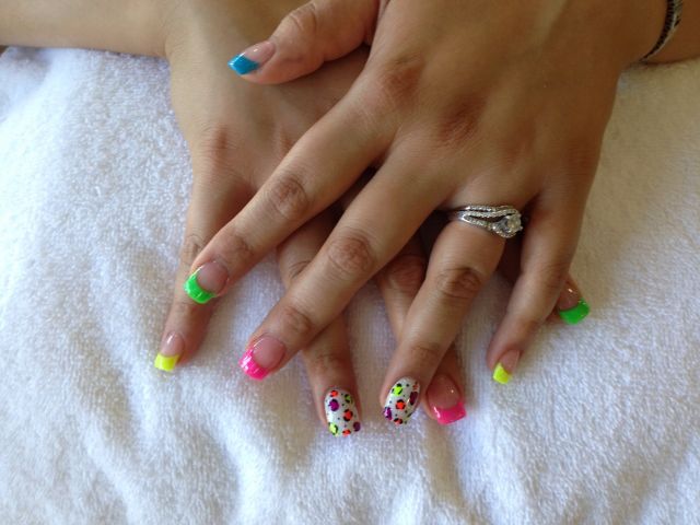 Neon rainbow French tips in green, yellow, pink and blue with a polka-dot accent