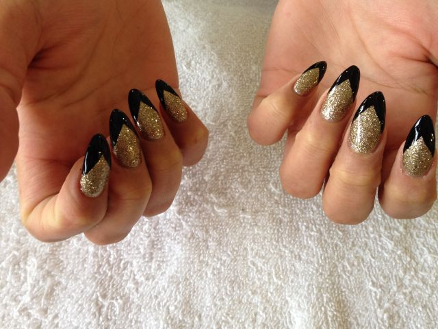 Gold glitter almond nails with black chevron tips