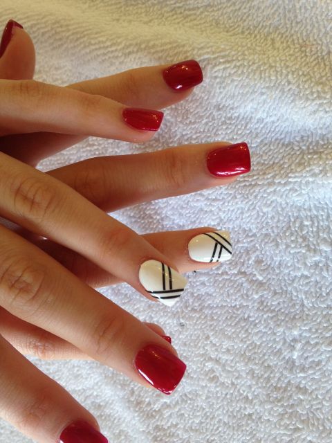 Red gel manicure with white and black striped accent nails